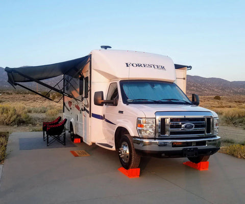White Class C RV with Orange Wheel Chocks - Desert Camping Setup | United RV Parts