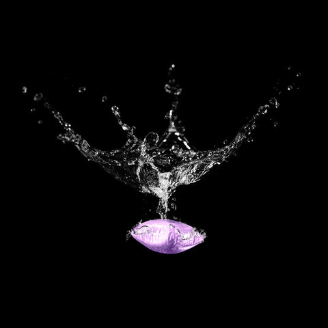 Lavender Camco TST RV Toilet Treatment Drop-In Packet Splashing into Water - Action Shot | United RV Parts