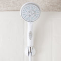 White Camco 43714 RV Handheld Shower Head with On/Off Switch in Wall Holder - Front Lifestyle View | United RV Parts