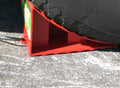 Red Valterra Wheel Chock Secured Under RV Trailer Tire on Pavement - In-Use View | United RV Parts