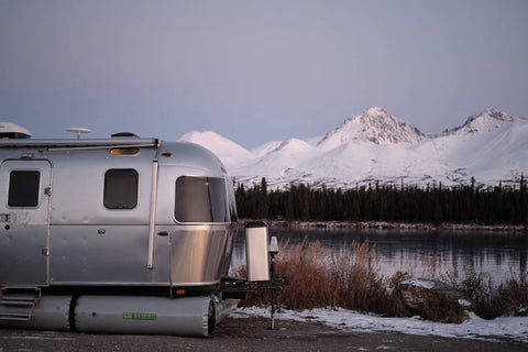 AIRSKIRTS Inflatable RV Skirting - Airstream Trailer Front Corner View at Winter Lakeside Camp | United RV Parts
