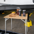 Bamboo Folding Table in Use - RV Campsite Setup with Drinks and Bowl | United RV Parts