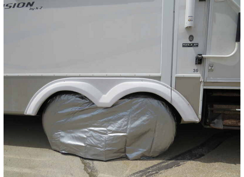 ADCO Silver Vinyl Double Axle Tire Cover Installed on RV - Lifestyle Side View | United RV Parts