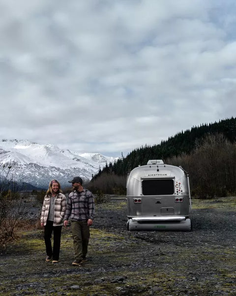 Silver Airstream Trailer with Inflatable RV Skirting - Mountain Camping Scene | United RV Parts